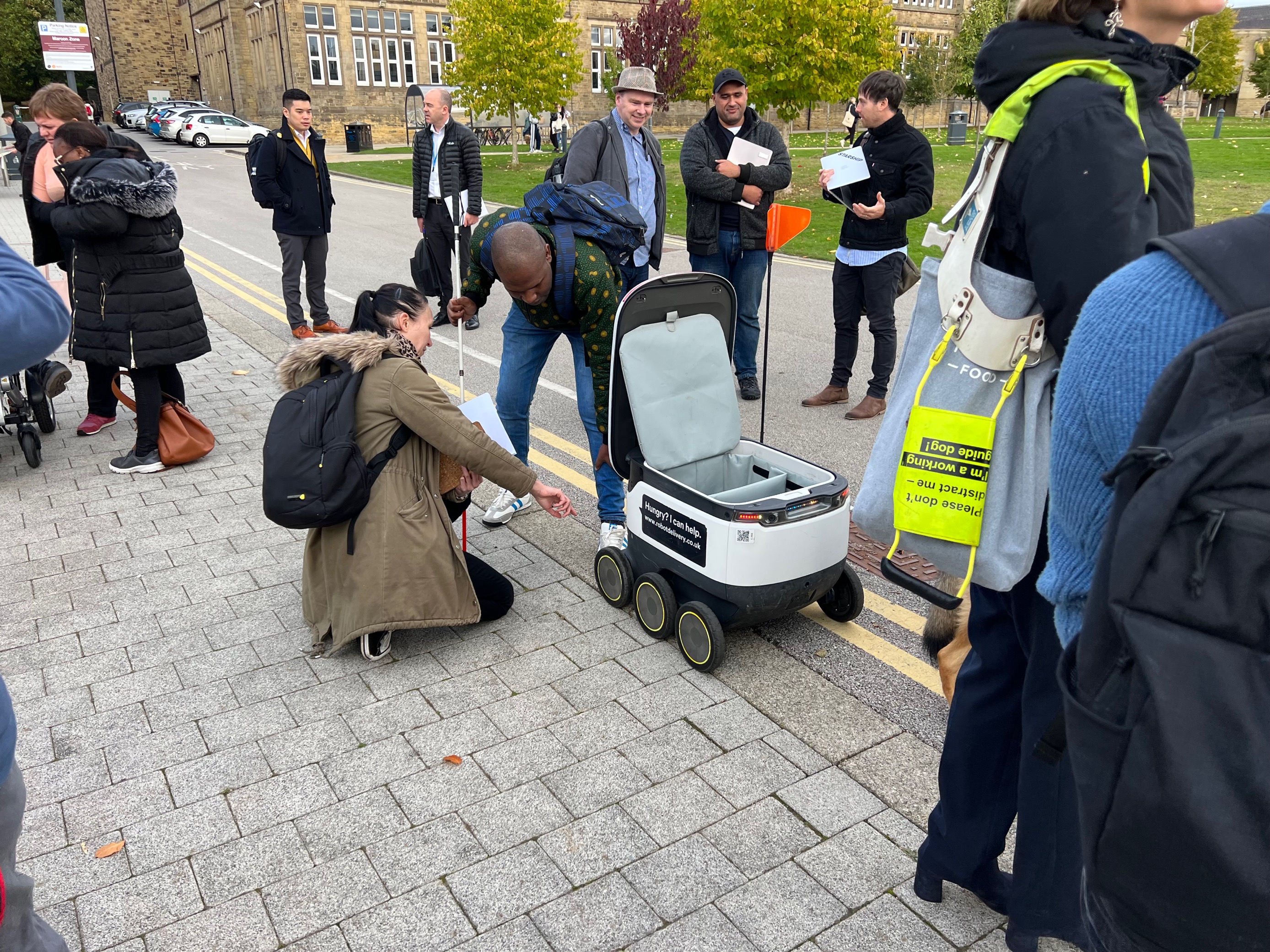 Main image: People inspect a Starship delivery robot; credit: Leeds City Council